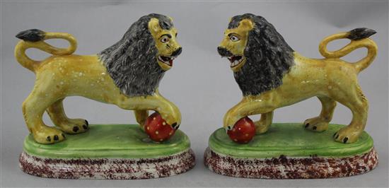 A pair of British pottery figures of lions, c.1820, 16cm., restorations